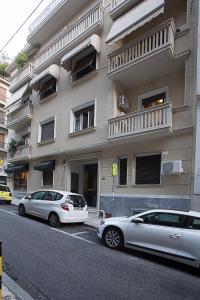 deux voitures garées devant un bâtiment dans l'établissement Dimokritou 4 Apartment, à Athènes