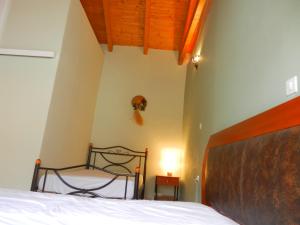 een slaapkamer met een bed met een houten hoofdeinde bij Thalia's Stone house in Ipsilándis