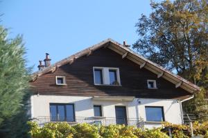 ein weißes Haus mit schwarzem Dach und Fenstern in der Unterkunft Chalet du Toit Vosgien in Gérardmer