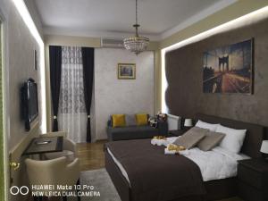 a bedroom with a large bed and a couch at Knez Mihailova Apartman in Belgrade