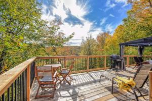 a deck with chairs and a table and a grill at Modern Chalet with Mountain and Lake view by Reserver.ca in Sainte-Adèle