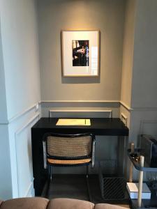 a desk with a chair and a picture on the wall at Suites Menaggio in Menaggio