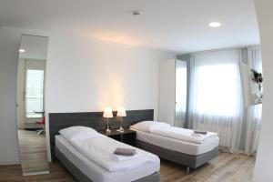 a hotel room with two beds and a mirror at looks-inn in Viernheim