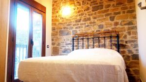 a bed in a room with a stone wall at BanastónEra in Usana