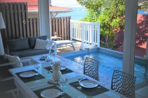 a patio with a table and chairs and a swimming pool at Kazarev in Terre-de-Haut
