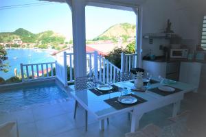 a dining room table with a view of the water at Kazarev in Terre-de-Haut