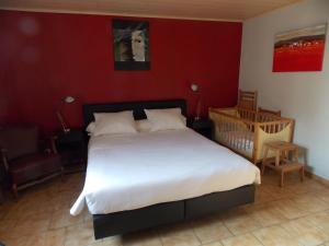 una camera con un grande letto e una culla di B&B De Linde a Wijtschate