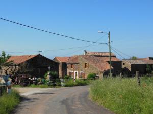 an empty road in front of a group of houses at Grand Gîte à la ferme in Les Costes-Gozon