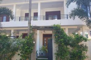 a white building with a balcony on top of it at Rohan's Residence in Kandana
