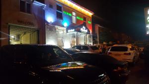 een groep auto's die 's nachts op straat geparkeerd staan bij Ababeel Hotel in Birmingham