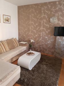 a living room with a couch and a table at Harmony apartman in Bijeljina