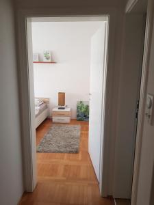 an open door to a bedroom with a bed and a rug at Harmony apartman in Bijeljina
