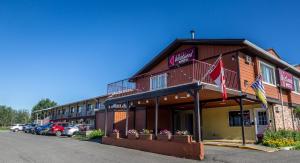 budynek hotelowy z samochodami zaparkowanymi na parkingu w obiekcie Westwood Motel 100 Mile House w mieście One Hundred Mile House