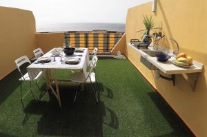 カンデラリアにあるEncantador 120 m2 vistas al mar y montañaのテーブル、シンク、テーブルと椅子が備わる客室です。