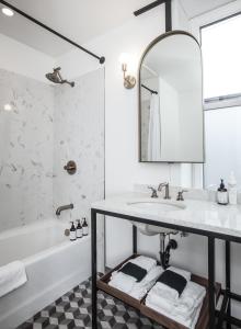 a bathroom with a sink and a tub and a mirror at Eleven Revelstoke Lodge in Revelstoke
