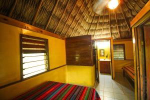 a room with a bed and a window in a room at Cohune Palms River Cabanas in Bullet Tree Falls