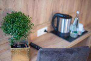 una maceta sentada en una mesa junto a una cafetera en Hotel Leo en Eggenstein-Leopoldshafen