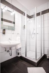La salle de bains est pourvue d'un lavabo et d'une douche. dans l'établissement Hotel Leo, à Eggenstein-Leopoldshafen