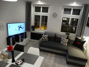 a living room with a couch and a tv at APARTAMENT "Eli" in Toruń
