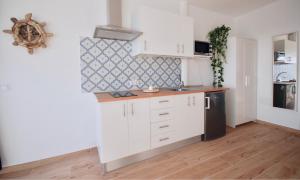 Una cocina con gabinetes blancos y un refrigerador negro. en Sea Lovers Jacuzzi Fuerteventura, en Gran Tarajal