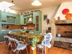 a kitchen with green cabinets and a table with chairs at Résidence Villa Smeralda in Telti