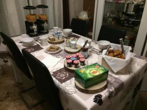 a table with a table cloth with cakes and pastries on it at Au lévrier de chessy in Chessy
