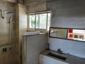 a bathroom with a sink and a shower and a mirror at Cenacle B & B in Chenggong +33 photos