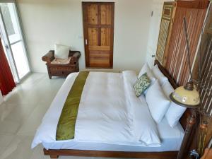 een slaapkamer met een wit bed en een groene deken bij Cenacle B & B in Chenggong