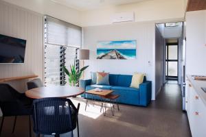 sala de estar con sofá azul y mesa en Reflections Shaws Bay - Holiday Park en Ballina