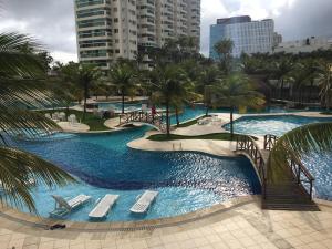 a resort with two pools with chairs and palm trees at Apartamento Bora Bora in Rio de Janeiro