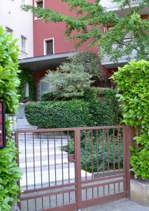 uma cerca em frente a um edifício com arbustos em B&B Villa Lattes em Vicenza