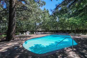 a swimming pool in a yard with trees at Chateau De Montagne #23 Condo in Mammoth Lakes