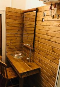 eine Holzwand mit einem Waschbecken auf einem Holztisch in der Unterkunft Nexus Kulcsoshaz Bukkloka Gyimes in Făgeţel