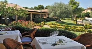 a restaurant with tables and chairs and a garden at Caprice Vell Mari Hotel & Resort - New Opening 2026 in Can Picafort