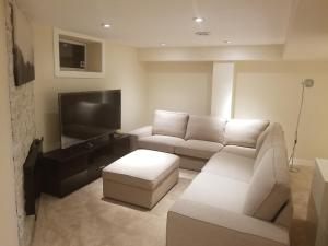ein Wohnzimmer mit 2 Sofas und einem Flachbild-TV in der Unterkunft Your perfect stay away from home in Winnipeg
