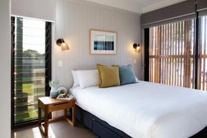 a bedroom with a large bed and a large window at Reflections Shaws Bay - Holiday Park in Ballina