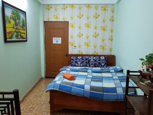 a bedroom with a bed and a curtain and a table at Hanu's House in Hanoi