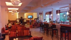 a restaurant with a bar and people sitting at tables at Ipsos Beach Hotel in Ipsos