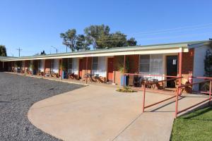 a motel building with a sidewalk in front of it at cross roads motel in Cobar