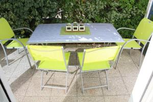 a table and chairs with a blue table and yellow chairs at La Marinière in Mesquer