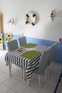 a dining room table with chairs and a table with a tableablish at La Marinière in Mesquer