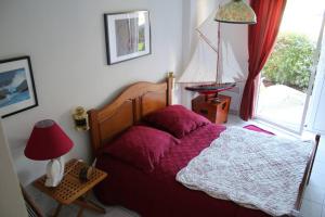 a bedroom with a bed and a lamp and a window at La Marinière in Mesquer
