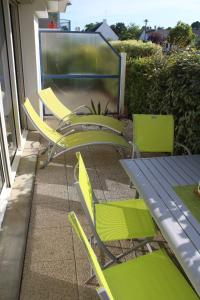a group of yellow chairs and a table on a patio at La Marinière in Mesquer