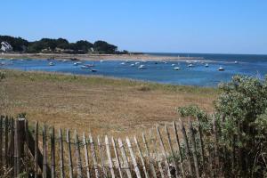 a fence in front of a body of water with boats at La Marinière in Mesquer +2 photos
