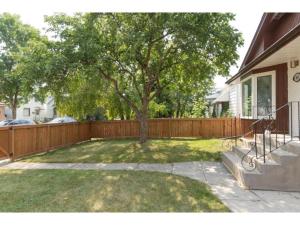 un patio con una valla de madera y un árbol en Your perfect stay away from home en Winnipeg