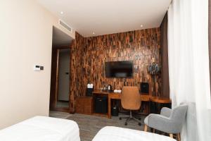 a hotel room with a desk and a television at East Astana Hotel in Astana