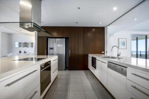 a large kitchen with white counters and a sink at The Wave Resort in Gold Coast