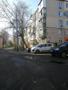 two cars parked in a parking lot next to a building at Апартаменты на Ивана и Юрия Лип in Odesa