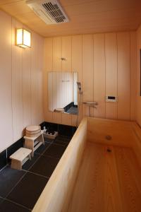 a bathroom with a tub and a toilet and a mirror at Touchian in Okayama