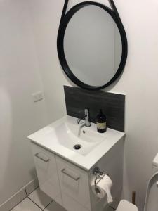 a bathroom with a sink and a mirror at Bunk Inn Hostel in Bundaberg